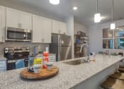 Thumbnail 30 of 53 - a kitchen with granite counter tops and stainless steel appliancesat Blue Ridge Commons Apartments, Roanoke, VA, 24017