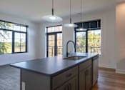 Thumbnail 2 of 29 - A modern kitchen with a large island and pendant lights at Aviator Lofts, Newport News, Virginia