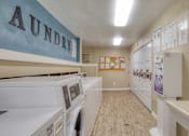 Thumbnail 16 of 21 - A laundry room with washers and dryers.