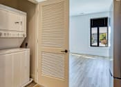 Thumbnail 6 of 29 - A white refrigerator is in a kitchen next to a white door at Aviator Lofts, Virginia 23602