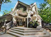 Thumbnail 45 of 67 - A house with a green roof and a porch with steps leading up to it.
