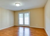 Thumbnail 3 of 21 - the living room of an empty house with wood floors and a door to a balcony