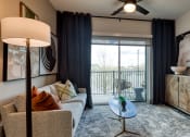 Thumbnail 8 of 38 - a living room with a couch and a door to a balcony at Aura Stonebridge, Richmond, 23225