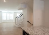 Thumbnail 22 of 81 - a kitchen and living room with white walls and wood floors at Ainsworth, Richmond, 23228