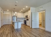 Thumbnail 9 of 40 - an open kitchen and living room with white walls and wood flooring at The Walker Virginia Center, Glen Allen, VA, 23059