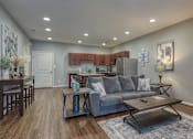Thumbnail 18 of 44 - A modern living room with a grey couch and a wooden coffee table.