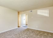 Thumbnail 14 of 26 - A room with a carpeted floor and a staircase leading to another room.