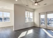 Thumbnail 30 of 47 - an empty living room with windows and a ceiling fan at The Port at East Beach Apartments and Marina, Norkfolk, VA, 23518