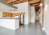 Thumbnail 10 of 46 - a kitchen with white walls and wood cabinets at The Hudson, Richmond, VA