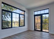 Thumbnail 4 of 29 - A room with a large window and a sliding glass door at Aviator Lofts, Newport News, 23602