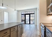 Thumbnail 3 of 29 - A kitchen with a large island and a sliding glass door at Aviator Lofts, Newport News, 23602