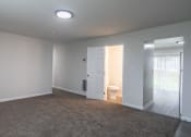 Thumbnail 6 of 36 - an empty living room with a door to a bathroom and a toilet