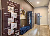 Thumbnail 3 of 16 - A hallway with a sign that says "Riveting at its finest" and a blue sofa.