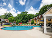 Thumbnail 24 of 39 - A swimming pool surrounded by a fence and trees.