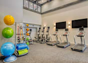 Thumbnail 29 of 33 - A gym with a variety of equipment including treadmills, exercise balls, and resistance bands.