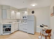 Thumbnail 1 of 33 - A kitchen with white appliances and cabinets.