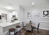 Thumbnail 4 of 56 - A kitchen with a bar and chairs.