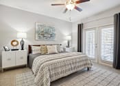 Thumbnail 9 of 56 - A bedroom with a large bed and a ceiling fan.