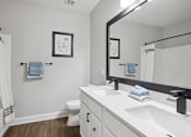 Thumbnail 12 of 56 - A bathroom with a toilet, sink, and mirror.