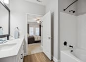 Thumbnail 13 of 56 - A white bathroom with a white tub and sink.