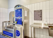 Thumbnail 30 of 40 - A water fountain with a blue sign on it.