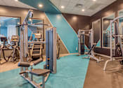 Thumbnail 25 of 40 - A gym with a variety of equipment including a leg press machine.