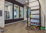 Thumbnail 26 of 40 - A gym with a rack of dumbbells and a bench.