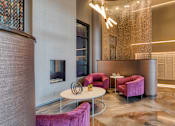 Thumbnail 17 of 40 - A modern living room with a pink sofa and a white coffee table.