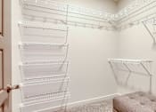 Thumbnail 38 of 40 - A room with a pink ottoman and a wall-mounted shelving unit.