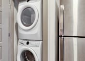 Thumbnail 39 of 40 - A white washing machine is stacked on top of another white washing machine in a kitchen.