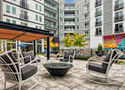 Thumbnail 4 of 40 - A patio with a fire pit and chairs.