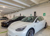 Thumbnail 31 of 40 - A white car is parked in a parking garage.