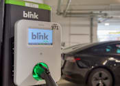 Thumbnail 32 of 40 - A Blink charging station is plugged into a car.