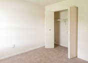 Thumbnail 23 of 36 - A room with a carpeted floor and a closet with a door open.