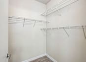 Thumbnail 66 of 67 - A walk-in closet with shelving and a door.