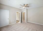 Thumbnail 65 of 67 - A room with a ceiling fan and carpeted floor.