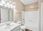 Thumbnail 64 of 67 - A white bathroom with a toilet, sink, and bathtub.