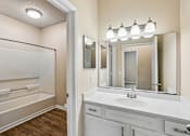 Thumbnail 57 of 67 - A bathroom with a white sink and a large mirror.