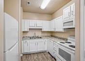 Thumbnail 50 of 67 - A kitchen with white appliances and cabinets.