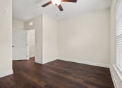 Thumbnail 4 of 27 - an empty living room with wood floors and a ceiling fan