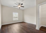 Thumbnail 13 of 27 - an empty living room with wood floors and a ceiling fan