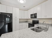 Thumbnail 7 of 27 - a kitchen with granite counter tops and black appliances