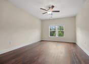 Thumbnail 9 of 27 - an empty living room with wood floors and a ceiling fan