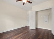 Thumbnail 10 of 27 - an empty living room with wood floors and a ceiling fan