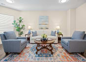 Thumbnail 15 of 27 - a living room with couches and chairs and a table