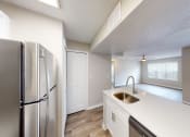 Thumbnail 29 of 40 - a kitchen with white countertops and a stainless steel refrigerator