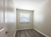 Thumbnail 21 of 39 - an empty room with wooden floors and a window