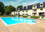Thumbnail 6 of 13 - A large swimming pool in front of apartment buildings.