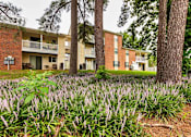 Thumbnail 1 of 13 - A building with a green lawn in front of it.