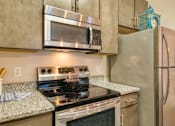Thumbnail 16 of 24 - a kitchen with stainless steel appliances and granite counter tops